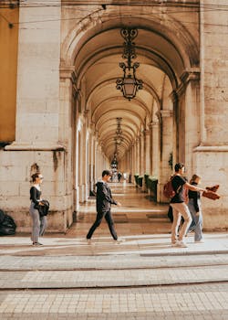 Tourists stroll through the magnificent historic arches of Lisbon, Portugal.