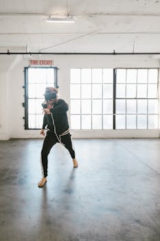 A person practices martial arts using VR in a spacious urban loft with large windows.