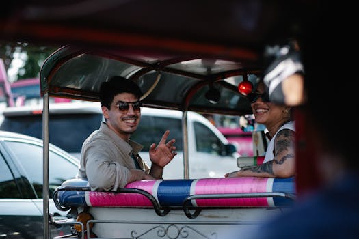 Friends smiling inside a colorful tuk-tuk, enjoying a sunny day ride outdoors.